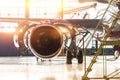 Opened hood airplane engine jet maintenance in the hangar stairs ,with bright light flare at the gate