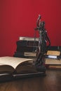 opened juridical books with lady justice statue on wooden table,