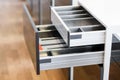 Opened kitchen drawer with cutlery tray. Two drawers are hide behind the high front. Smart storage solution.