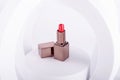 Opened lipstick on props on white background