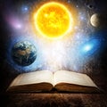 Opened magic book with sun, earth, moon, saturn, stars and galaxy. Concept on the topic of astronomy or fantasy. Elements of this Royalty Free Stock Photo