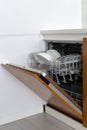 Opened modern dishwasher machine with plates and cups on kitchen Royalty Free Stock Photo