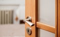 Opened modern wooden door into room, closeup detail on metal handle Royalty Free Stock Photo