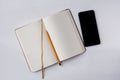 An opened note book with a bookmark, smartphone and a pencil isolated on grey background. Preparation for the business meeting Royalty Free Stock Photo