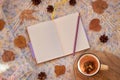 Opened notebook with blank pages surrounded by autumn leaves and cones on a woolen background. Flat lay, mock up