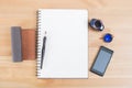 Opened notebook or notepad with pen, mobile and ink on wooden desk Royalty Free Stock Photo