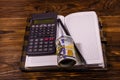 Opened notepad, one hundred dollar banknotes, scientific calculator and pencil on wooden table Royalty Free Stock Photo