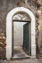 Opened old weathered door on a crumbling wall