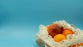 Opened organic cotton bag filled with oranges on the right side of the image with space on the left side for text. Isolated in