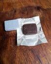 an opened pack of beef stock cubes with silver foil paper wrappers on an old vintage wooden tray