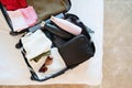 opened packed suitcase on bed in hotel room Royalty Free Stock Photo