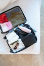 opened packed suitcase on bed in hotel room Royalty Free Stock Photo