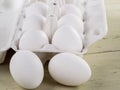 Opened packing with eggs and lying eggs next to a wooden background Royalty Free Stock Photo