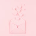 Opened paper envelope with fly out hearts as love message on soft pink color background. Valentine day concept for design.