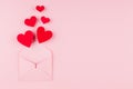 Opened paper envelope with fly out red hearts on soft pink color background. Copy space. Valentine day concept for design. Royalty Free Stock Photo