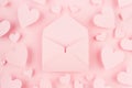 Opened paper envelope with hearts around on soft pink color background. Valentine day concept for design.