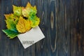 Opened paper envelope on old brown wooden background with yellow leaves. Vintage style of communication. Royalty Free Stock Photo