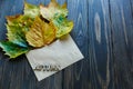 Opened paper envelope on old brown wooden background with yellow leaves. Vintage style of communication. Royalty Free Stock Photo