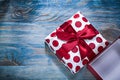 Opened present box with red knot on wooden board Royalty Free Stock Photo