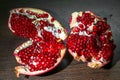 An opened ripe pomegranate fruit with red appetizing juicy seeds, seperating from the peel.
