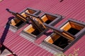 Opened roof windows. Skylight on red ceramic house tiles. Metal-plastic windows, sun tunnels. Building construction