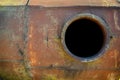 Opened rusty manhole on orange fuel tank
