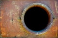 Opened rusty manhole on orange fuel tank