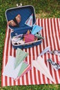 Opened Suitcase with Color Paper Planes on The White and Red Stripes Mat Royalty Free Stock Photo