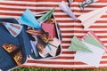 Opened Suitcase with Color Paper Planes on The White and Red Stripes Mat Royalty Free Stock Photo