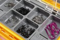 Opened tackle box with fishing hooks and accessories. Fishing hooks in box sections. Case for tackle elements. Fishing accessories