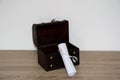 Opened treasure chest next to a blank rolled paper Royalty Free Stock Photo