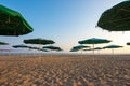 Opened umbrellas on a deserted evening sandy beach Royalty Free Stock Photo