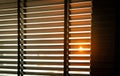 Opened venetian plastic blinds with sunlight in the morning. White plastic window with blinds. Interior design of living room Royalty Free Stock Photo