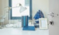 Opened white door to blur image of work table with lamp,pencil,book Royalty Free Stock Photo