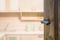 Opened wooden door to modern kitchen room.