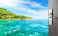 Opened wooden door to tourist snorkeling in tropical clear sea near the green island