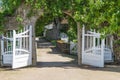 Opened wooden gate decorated with climbing plant Royalty Free Stock Photo