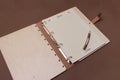 Opened wooden guests book with pen ready to write on brown colored paper background Royalty Free Stock Photo
