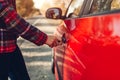 Opening car door. Woman opens red car with key on autumn road Royalty Free Stock Photo