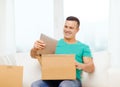 Opening cardboard box and taking out tablet pc Royalty Free Stock Photo