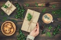 Opening Christmas present. Woman's hands holding decorated gift box on rustic wooden table. Overhead, flat lay, top view Royalty Free Stock Photo