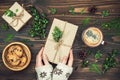 Opening Christmas present. Woman's hands holding decorated gift box on rustic wooden table. Overhead, flat lay, top view Royalty Free Stock Photo