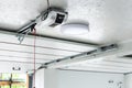 Opening door and automatic garage door opener electric engine gear mounted on ceiling with emergency cord. Double place empty