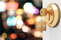 Opening door with golden house key chain on blurry bokeh background and mock up place for your advertisement. Home purchase Royalty Free Stock Photo