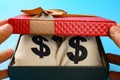 opening gift box full with US dollar bags carefully Royalty Free Stock Photo