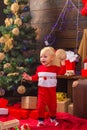 Opening gifts on Christmas and New Year. Happy child with a Christmas present on wooden background. Portrait kid with Royalty Free Stock Photo