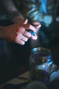 Opening the good stuff. an unrecognizable man opening a tin of cannabis while sitting with his friend at home.