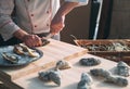 Opening the hollow and flat oysters. Chef opens oysters in the restaurant. Royalty Free Stock Photo