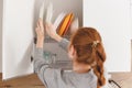 Opening kitchen cabinet door, woman putting plates into it Royalty Free Stock Photo