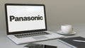 Opening laptop with Panasonic Corporation logo on the screen. Modern workplace conceptual editorial 4K clip